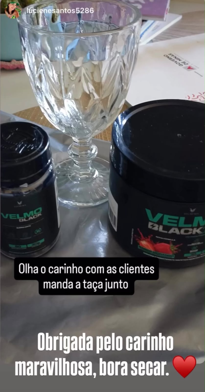 Cliente mostrando o VELMO Black que recebeu junto com uma taça de brinde